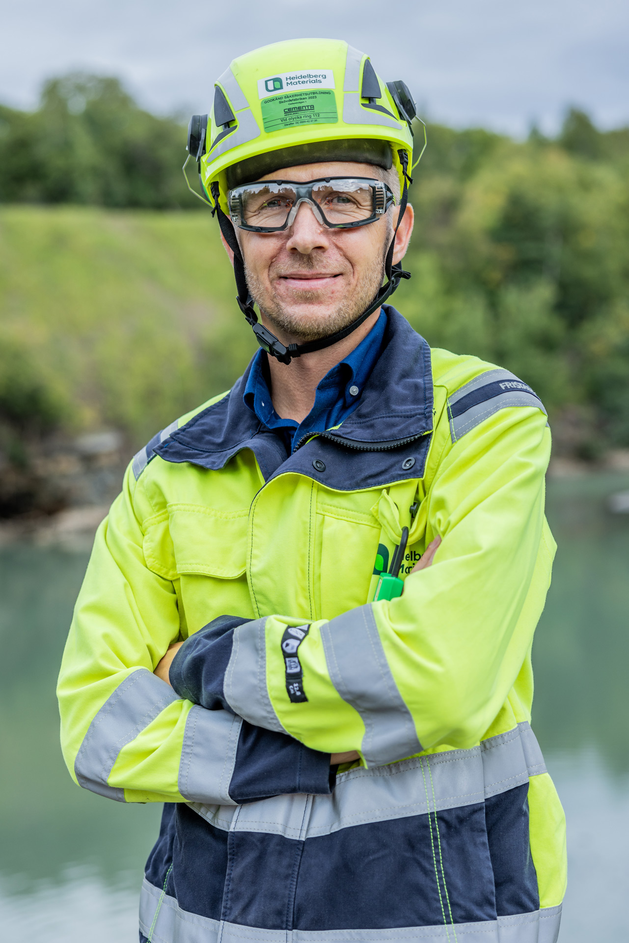 Man in protective clothing standing in front of a green landscape