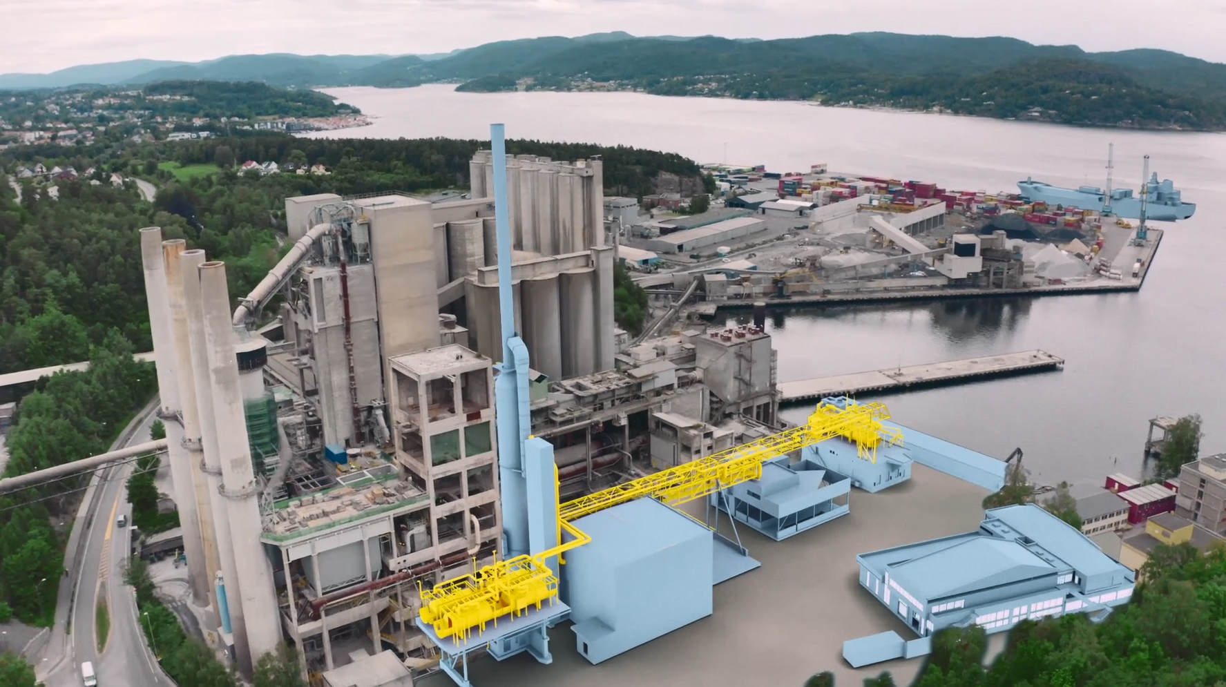 Large cement plant with metal structures, pipes, and the “Heidelberg Materials” logo-bearing tower against a clear sky. A blue and yellow part in front serves as an illustrative element, representing the expansion of the facility.