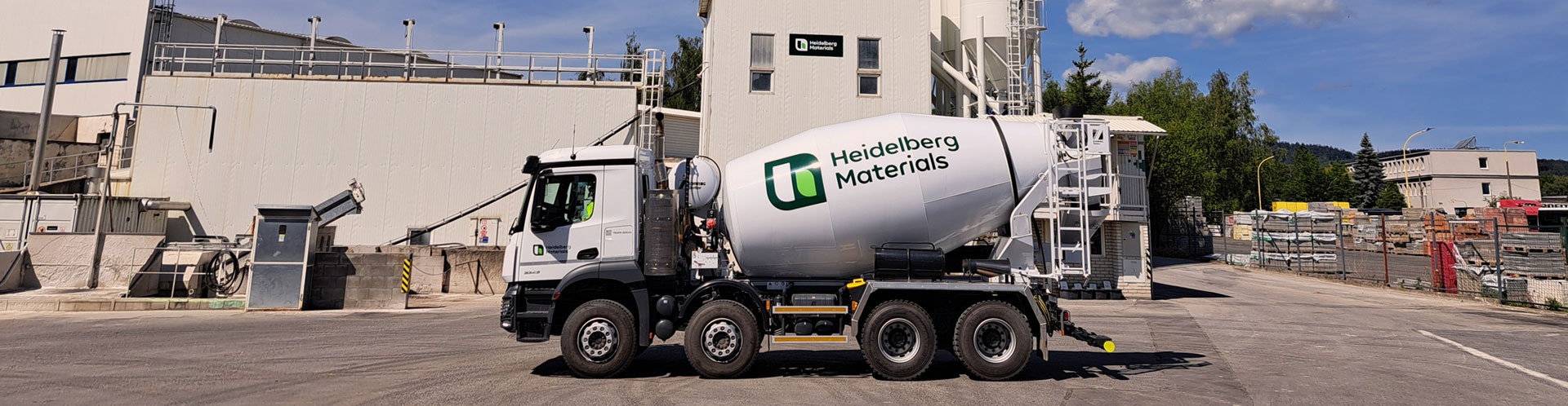 A Heidelberg Materials ready-mixed concrete truck parked at plant on a sunny day.