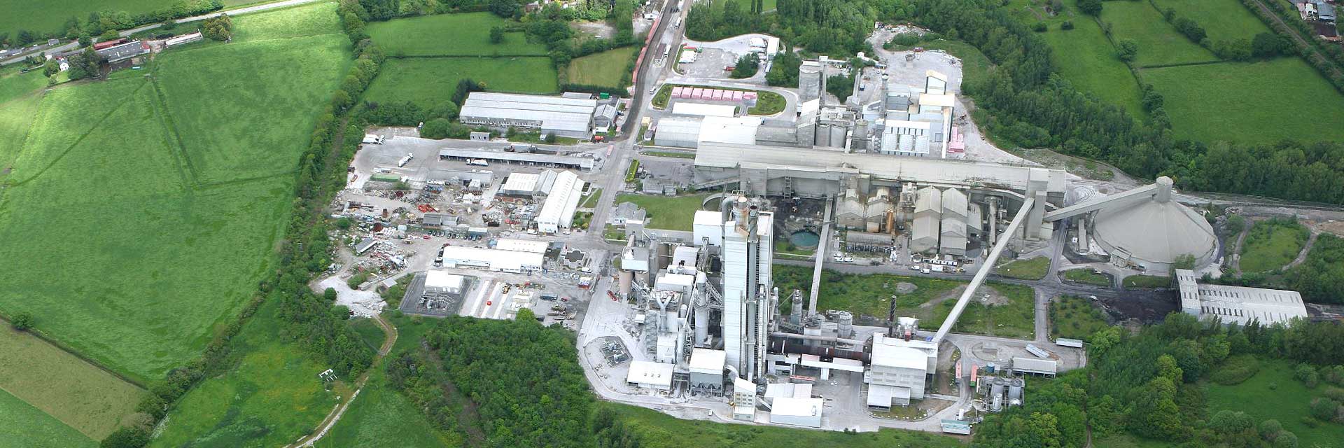 Aerial view of an industrial complex amid green fields, highlighting the contrast between industry and nature