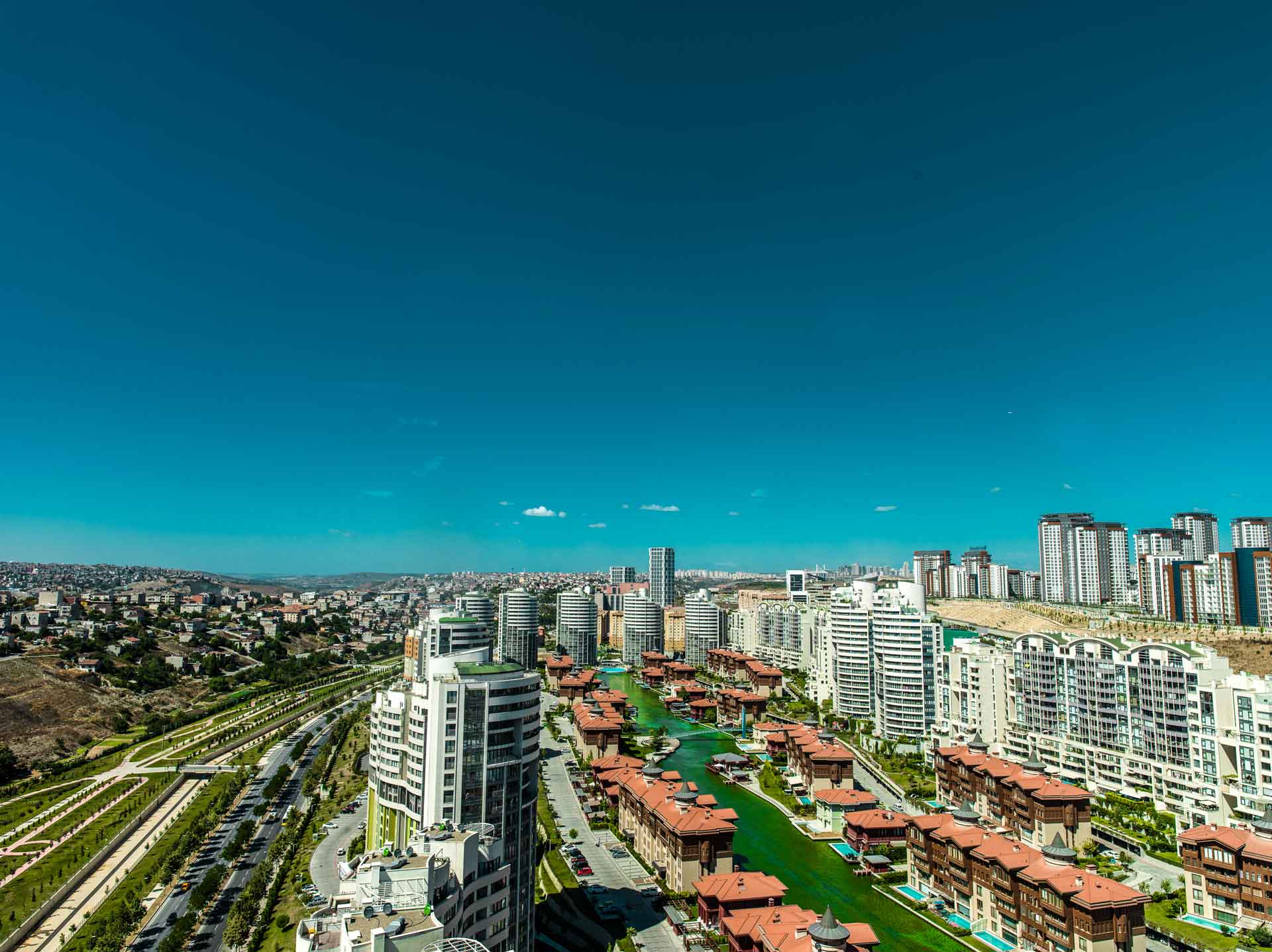 Panoramablick auf eine moderne Stadt mit Hochhäusern und einem Kanalnetz.