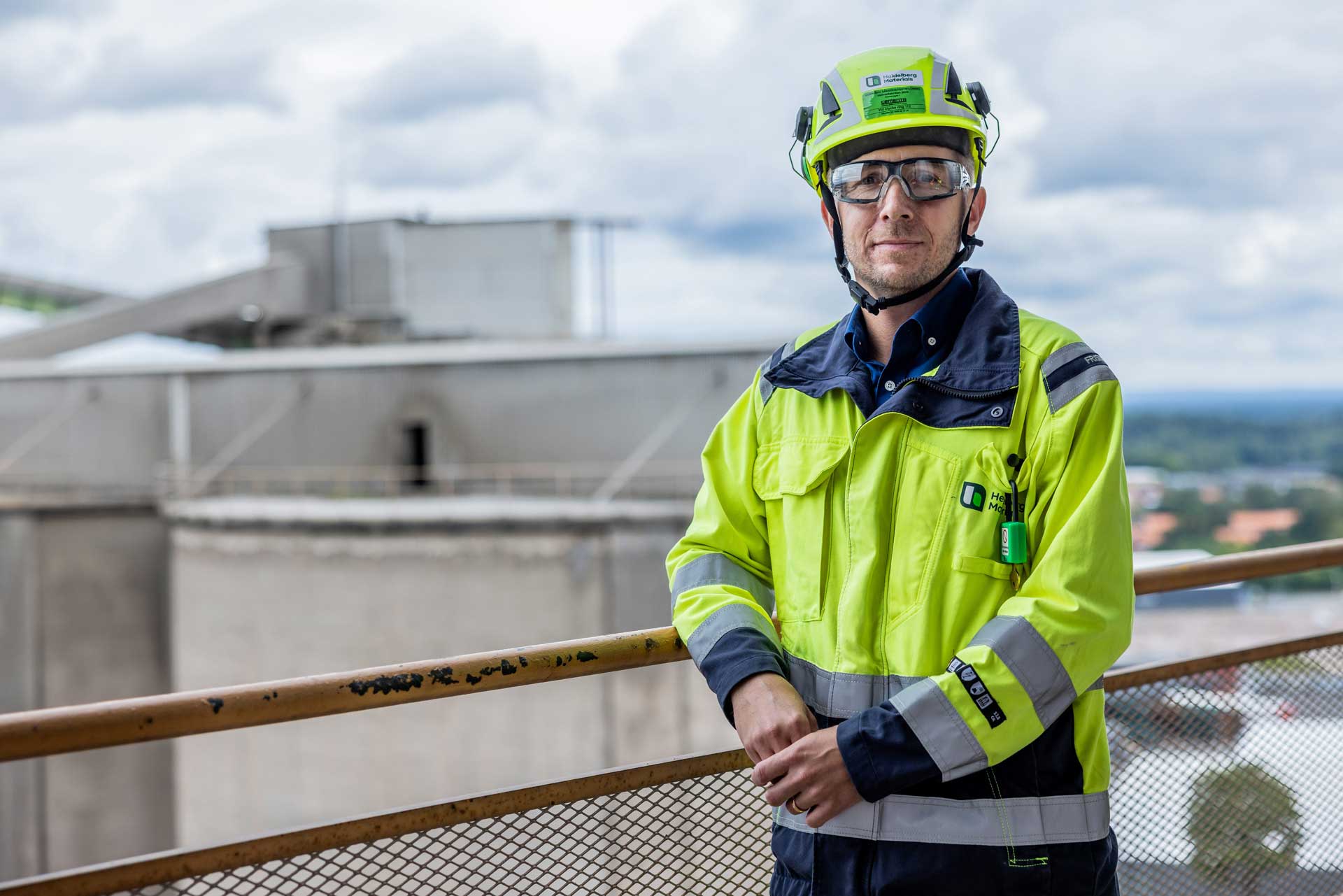 Man in protective clothes standing on the platform of a plant