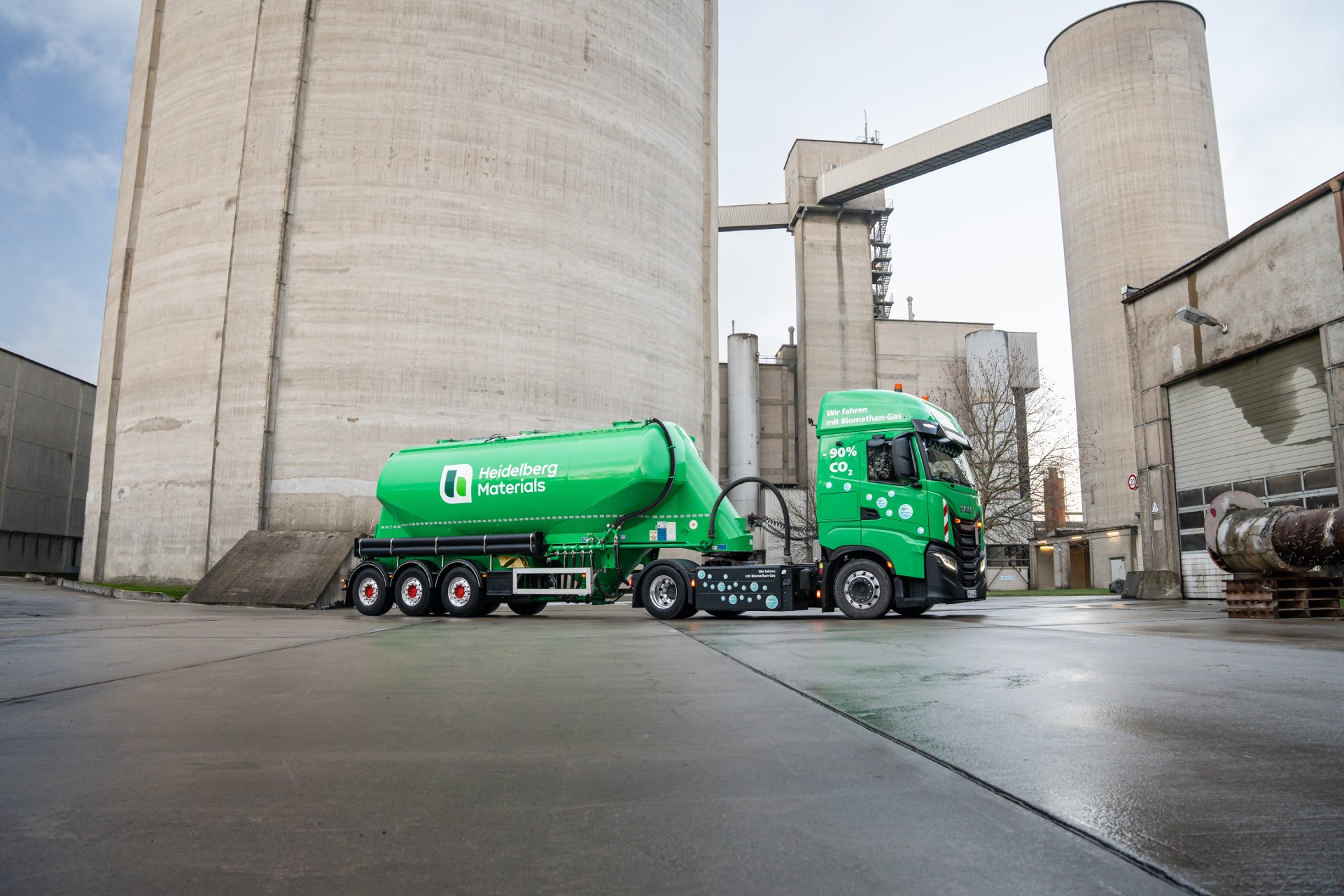 Grüner Silozug vor einem Industriegebäude