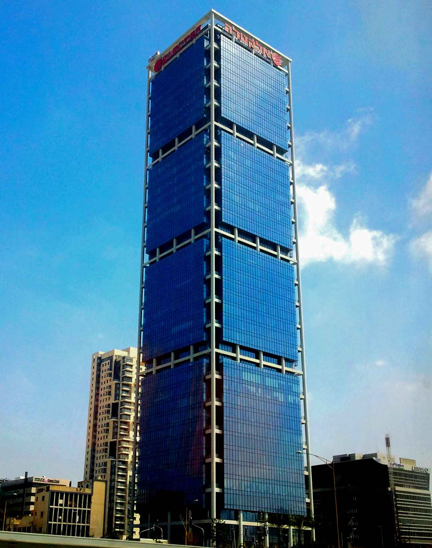 A skyscraper with a reflective blue glass facade reaches into the clear sky, labelled “IFC” at its pinnacle.